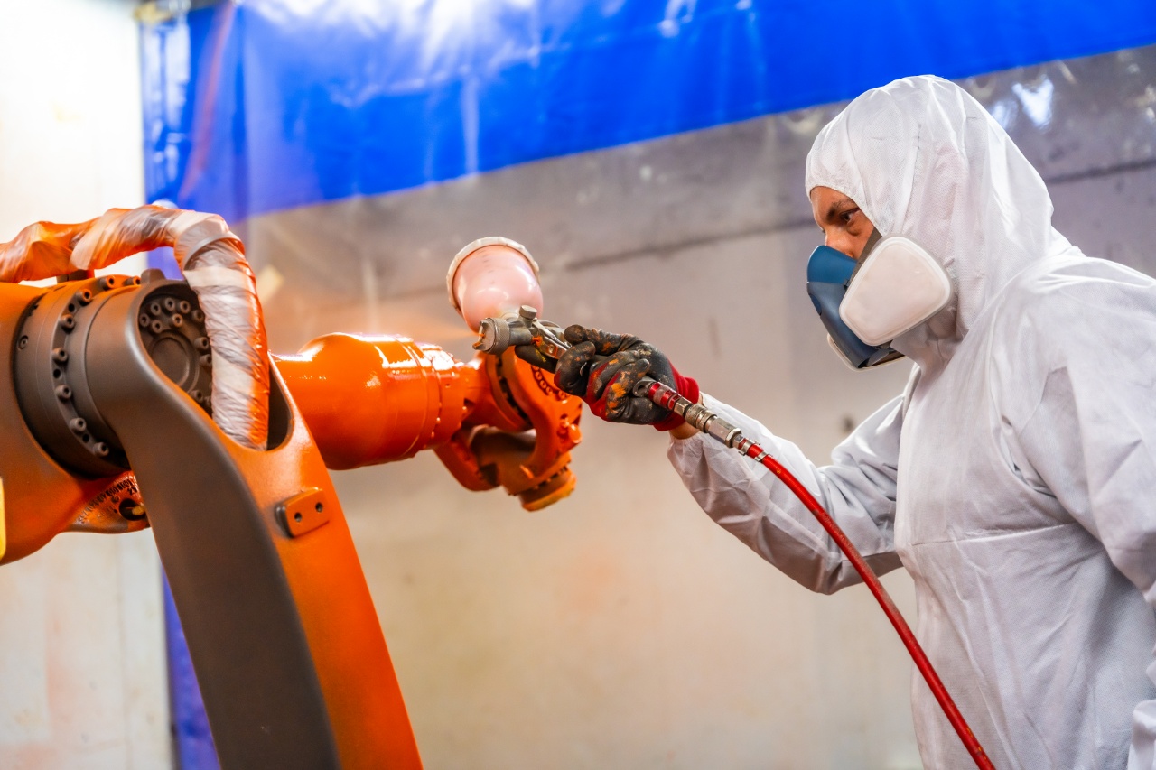 Poedercoaten van een industriële robotarm door een medewerker van Ten Bolscher Poedercoating.