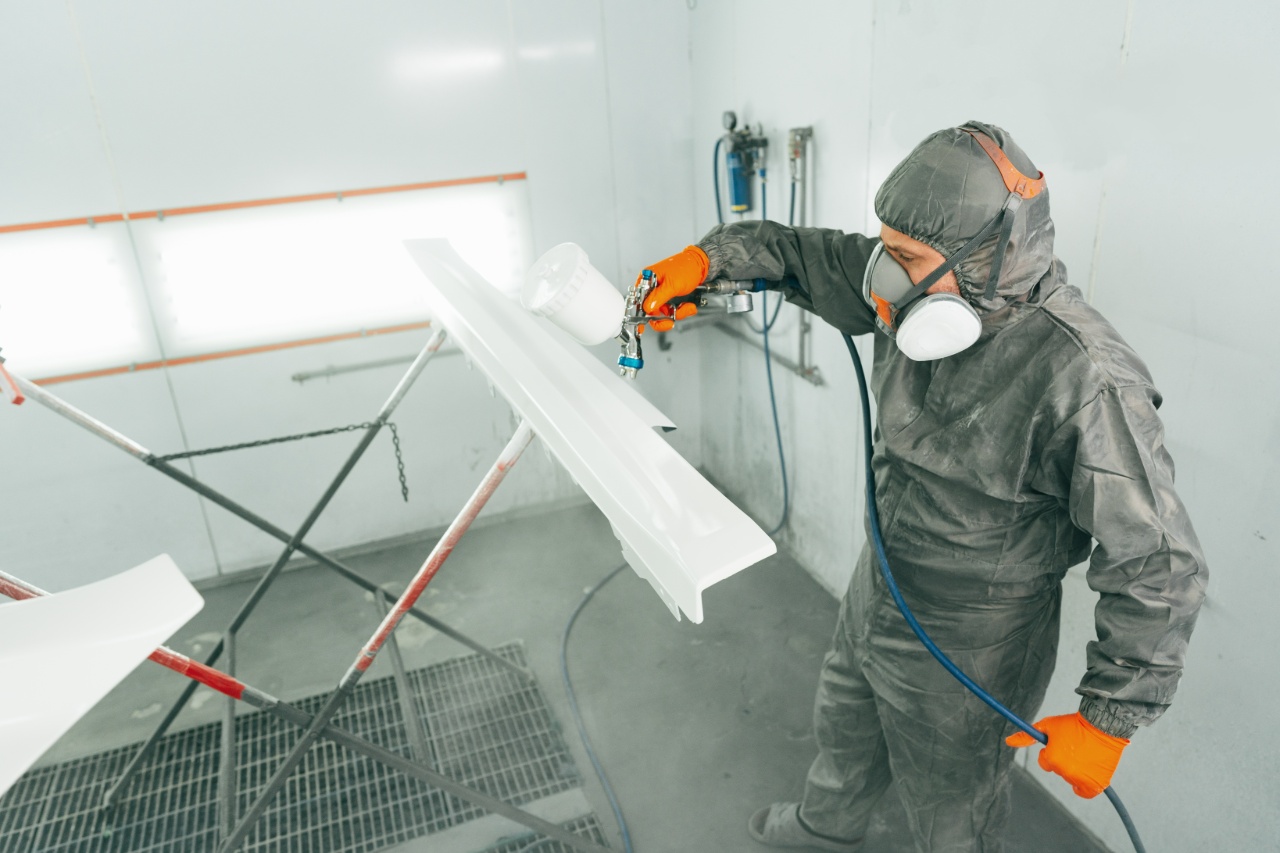 Poedercoaten van een metalen paneel in de spuitcabine door een medewerker van Ten Bolscher Poedercoating.
