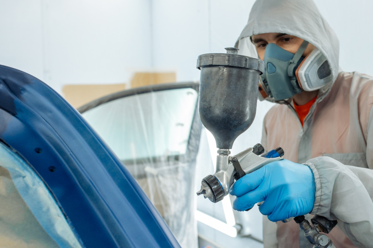 Poedercoaten van een metalen onderdeel in de spuitcabine door een medewerker van Ten Bolscher Poedercoating.